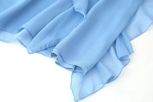 Close-up of light blue chiffon dress featuring vertical texture and delicate ruffled edge