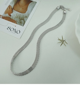 Macro detail of multi-strand silver woven necklace with lobster clasp and tag