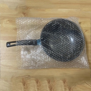 Detailed view of a mini non-stick frying pan safely wrapped in protective bubble wrap