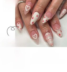 Detail of pink press-on nails with strawberry patterns and 3D heart pearl accents
