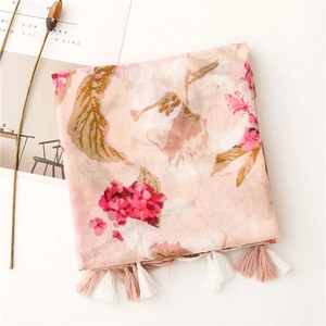 Close-up of pink floral linen scarf with fringe tassels and delicate flower print