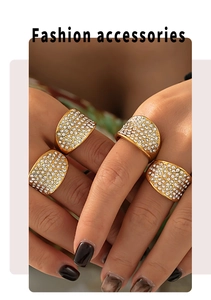 Primer plano de modelo luciendo anillos anchos dorados con pavé de circonitas brillantes