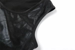 Détail du similicuir noir brillant et des coutures renforcées sur un ensemble deux pièces