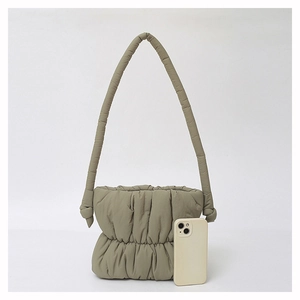 Macro shot of khaki pleated cloud bag in smooth nylon with smartphone for size scale