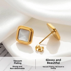 Detailed macro view of square gold earrings featuring white mother-of-pearl inlays