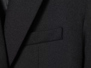 Close-up of black twill blazer pocket and lapel detailing with fine stitching