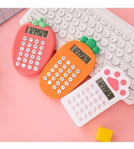 Close-up of cute strawberry and carrot shaped calculators on a creative pink desktop