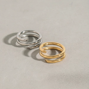 Détail de bagues en spirale en finition or et argent avec texture en acier inoxydable poli