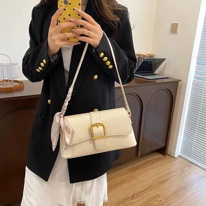 Off-white lychee texture shoulder bag with gold buckle and silk scarf on a model