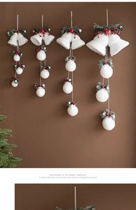 Detail of white flocked Christmas bells with green pine needles and red berries decor