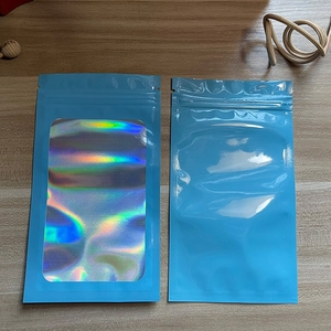 Detail view of blue holographic laser pouch with clear window on a wooden background