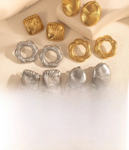 Detailed flat lay of geometric titanium steel earrings in gold and silver finish