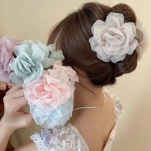 Detailansicht von Stoffblumen-Haarklammern in verschiedenen Pastellfarben an einem Model