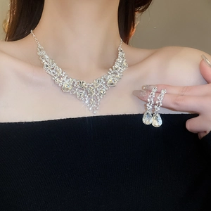Detail of silver waterdrop rhinestone necklace and earrings set worn on a model