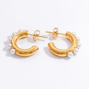Detailed view of 18k gold plated C-shaped earrings with inlaid white pearls