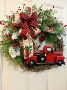 Close-up of farmhouse Christmas wreath with red truck and rustic buffalo plaid bow