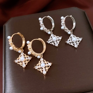 Vue détaillée des boucles d'oreilles losanges en or et argent avec perles et zircons