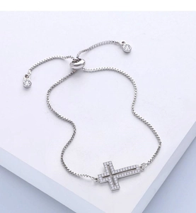 Detailed macro view of the silver cross bolo bracelet with sparkling micro-pave zircons