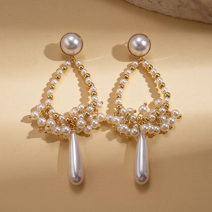 Vintage gold teardrop pearl earrings with baroque style design for women on beige background