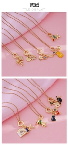 Detailed close-up of 18K gold plated necklaces featuring travel and academic theme pendants