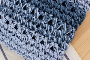 Macro shot of blue gradient hand-woven mesh texture and intricate fiber craftsmanship