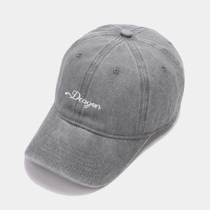 Macro detail of white Dragon embroidery on vintage dark gray washed denim baseball cap