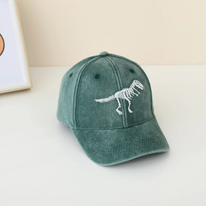 Dettaglio del ricamo dinosauro bianco su un berretto da baseball in cotone lavato verde scuro