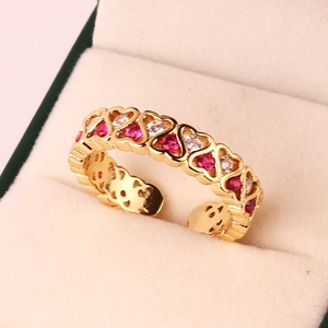 Detail of a golden heart open ring with red and white zircons in a jewelry box