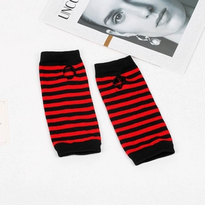 Close-up of red and black striped knitted arm warmers with thumb holes on white background