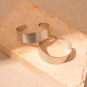 Détails des boucles d'oreilles créoles en métal argenté brossé avec texture mate raffinée