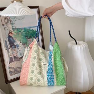 Detail of floral patchwork canvas tote bag with Sozakka brand label in a lifestyle setting