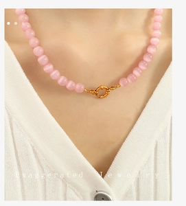 Close-up of pink cat eye beaded necklace with a decorative golden spring clasp
