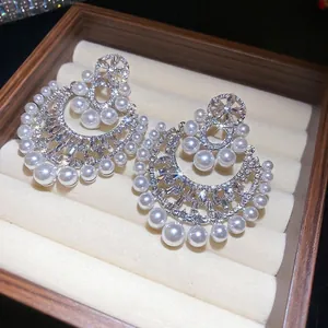 Eleganti orecchini vintage con perle e zirconi brillanti in un portagioie di velluto di lusso