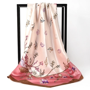 Close-up of pink gradient silk scarf with floral and seashell patterns and brown hem