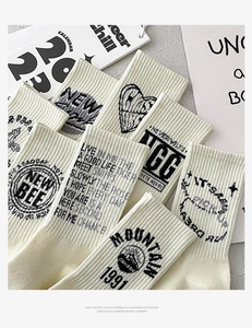 Close-up of white cotton socks featuring vintage black embroidery and typography details