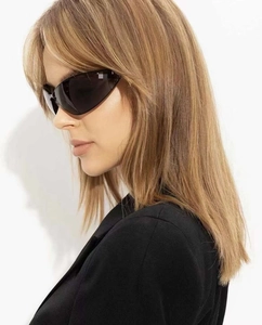 Close-up of black oversized cat-eye sunglasses with thick frames and curved temple design