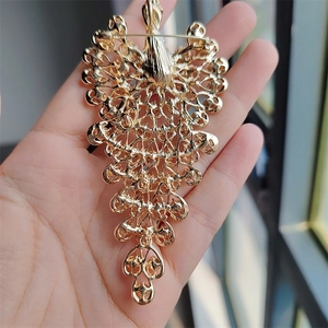Detailed back view of a large gold peacock brooch showing the secure pin clasp and hollow metalwork