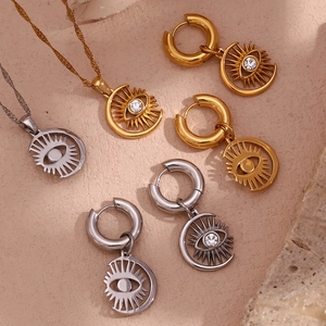 Macro shot of 18K gold and silver celestial moon eye jewelry set on stone texture