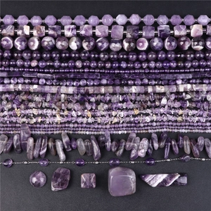 Macro shot of various purple amethyst beads including round, faceted and raw stones