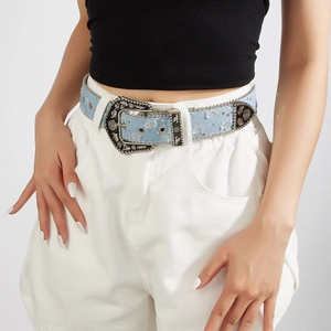 Detail view of light blue denim belt with vintage Western silver engraved buckle for women