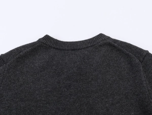 Detailed view of dark grey knitted cardigan with ribbed neckline and premium wool texture