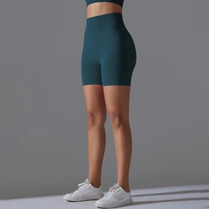 Detail view of seamless high-waisted yoga shorts in deep teal showing squat-proof fabric texture
