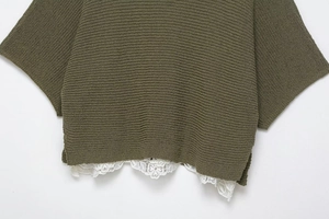 Detail of the olive green knitted top showing delicate white lace trim hem decoration