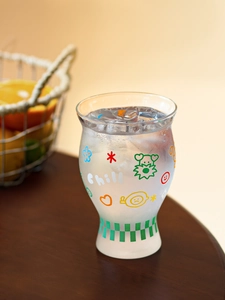 Close-up of heat-resistant chill glass with ice, bear pattern and green checkered base