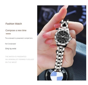 Detail of silver women's watch with faceted strap and dual calendar display on black dial
