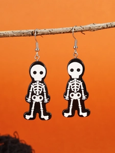 Close-up of black and white skull earrings hanging on hooks for Halloween decor