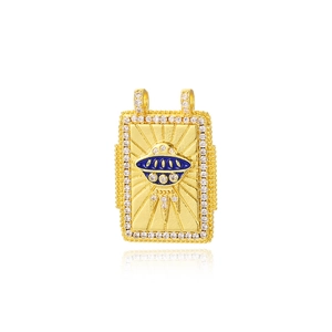Detail of a gold square pendant featuring a blue UFO design and sparkling rhinestone borders