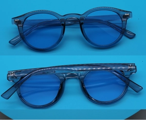 Detailansicht der runden Retro-Sonnenbrille mit ozeanblauen Gläsern und transparentem Rahmen