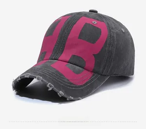 Close-up of distressed washed grey denim baseball cap with pink HB letter embroidery