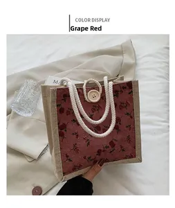 Detail of red floral linen handbag with rope handles and wooden button closure